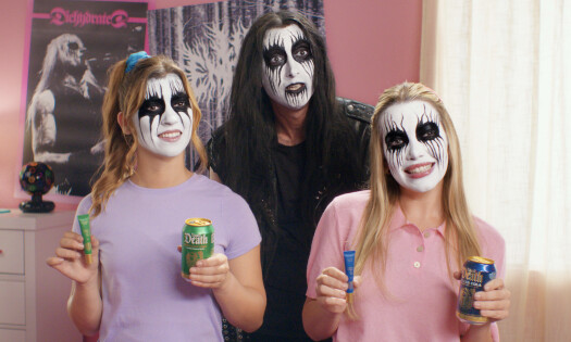 Two young girls and a man holding up the new elf x Liquid Death lip balm