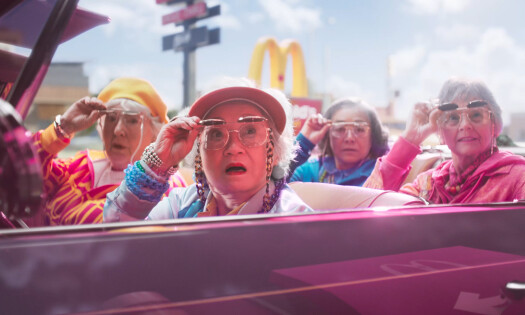 Elderly women behind a pink car