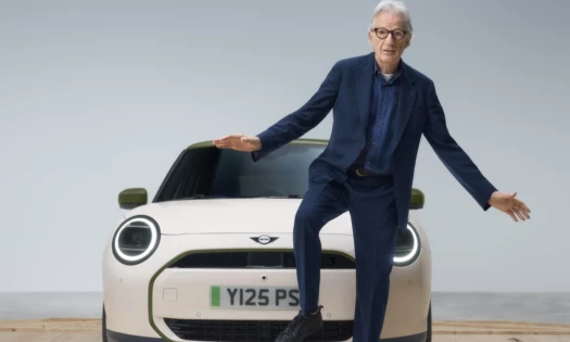 Designer Paul Smith posing in front of a MINI convertible car