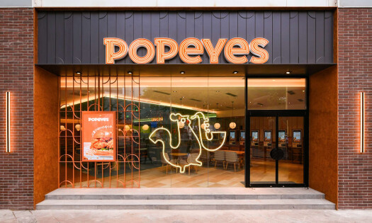 A Popeyes fried chicken sandwich pictured beside an order of french fries