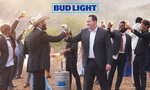 Post Malone and Shane Gillis make a beer toast surrounded by other wedding guests with the Bud Light keg in the middle