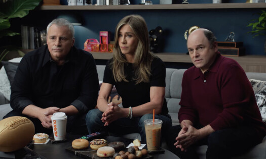 Matt LeBlanc, Jennifer Aniston, and Jason Alexander sitting on a couch with Dunkin' products looking bewildered