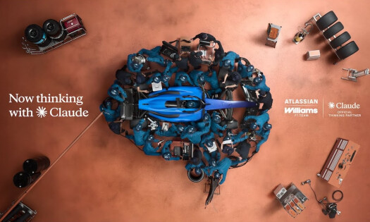 The Williams F1 racing team gathered around a race car in the formation of a brain shape, all wearing signature blue uniforms