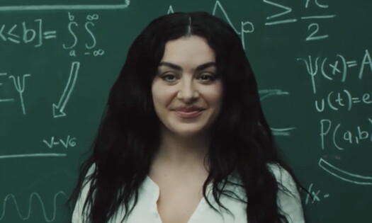 Charli XCX in front of a chalkboard
