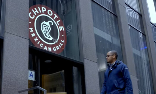 A man walking into a Chipotle Mexican Grill restaurant