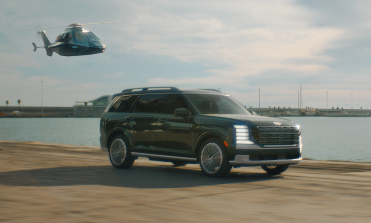 A Hyundai Palisade shown driving down a road