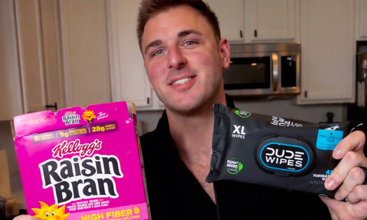 Jake Butt holding a box of Raisin Bran and DUDE Wipes in each hand