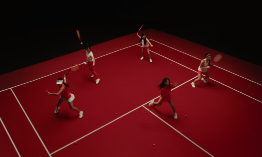 Tennis players on a red-colored pitch