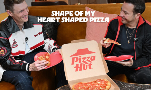 Backstreet Boys members Nick Carter and Howie Dorough eating a heart-shaped pizza from Pizza Hut