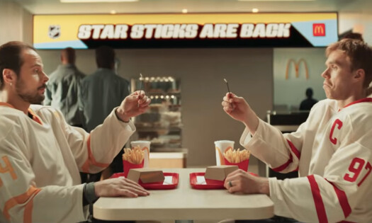 NHL hockey players Connor McDavid and Auston Matthews holding NHL Star Sticks while sitting at McDonald's