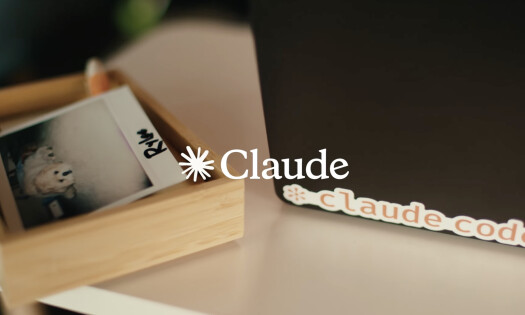 The Claude logo shown overtop of a desk with a photo of a dog
