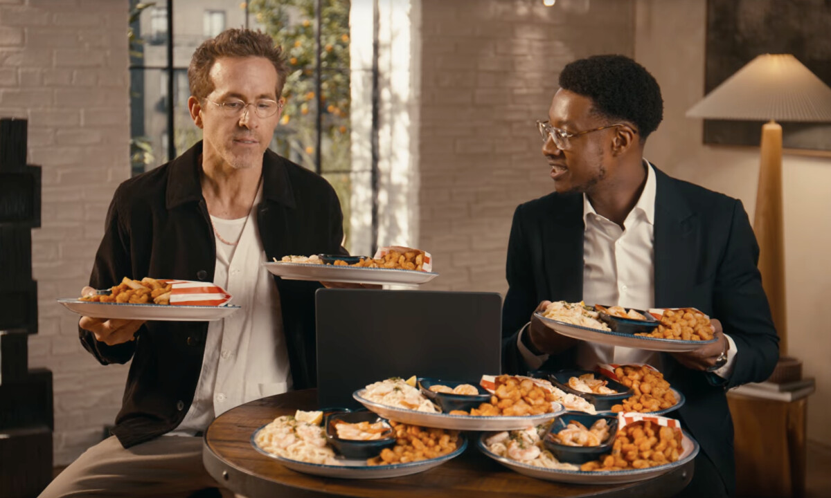 Actor Ryan Reynolds and Red Lobster CEO Damola Ademolekun shown in front of plates filled with shrimp