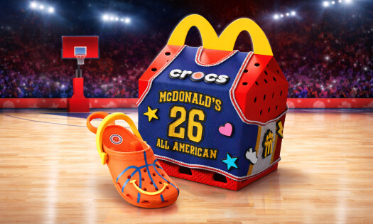 The Mcdonald's x Crocs Happy Meal box with an orange clogs keychain on a basketball court
