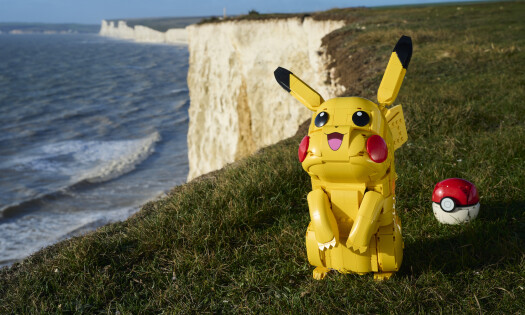 A LEGO Pikachu and Pokeball set pictured in front of a scenic waterfall
