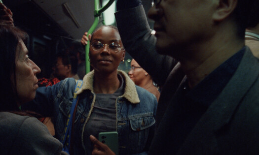 A woman on a bus watching two people converse