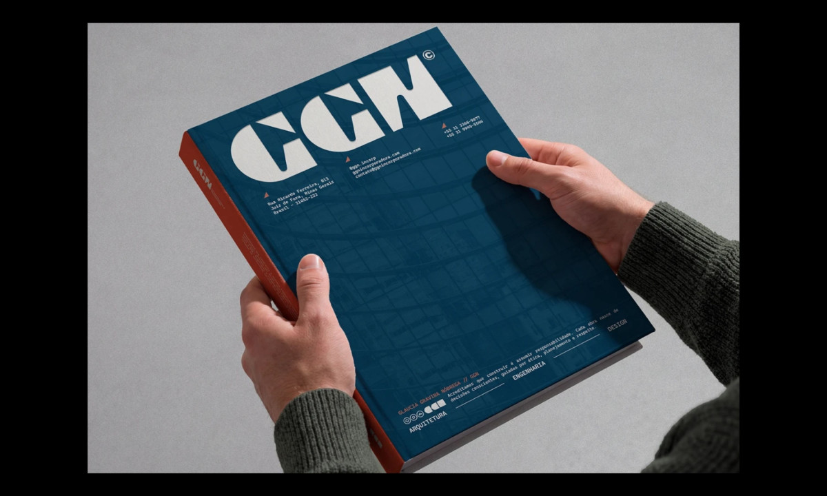 Person holding GGN brand book with large typographic cover and architectural imagery in deep blue tones