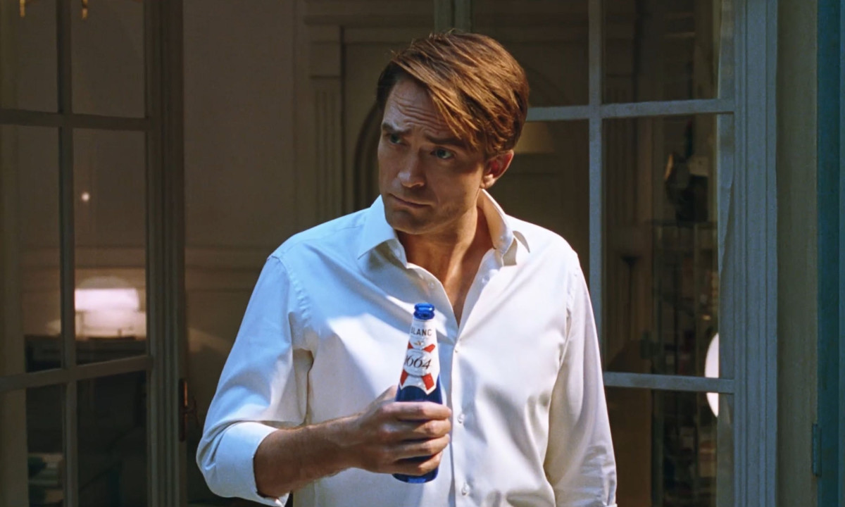 Man holding beer bottle in softly lit indoor lifestyle scene