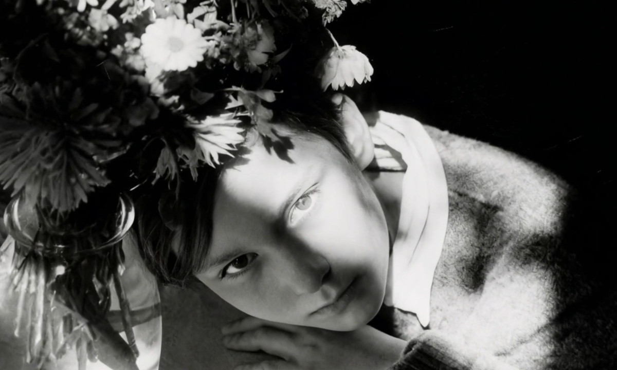 Close-up black-and-white portrait with flowers casting shadows