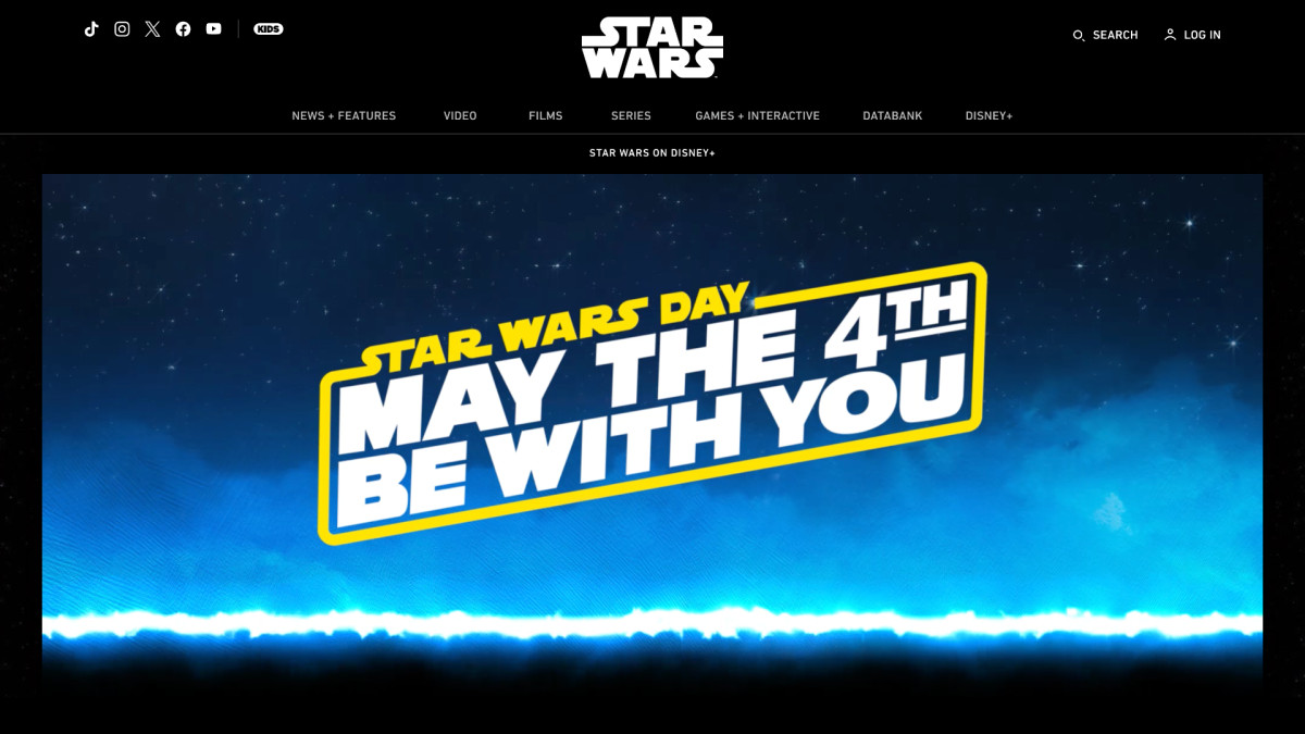 The starwars.com/starwarsday hub page on May 4, 2026, showing the full-viewport animated hero with the May the 4th Be With You lockup, lightsaber blue streak and starfield animation.