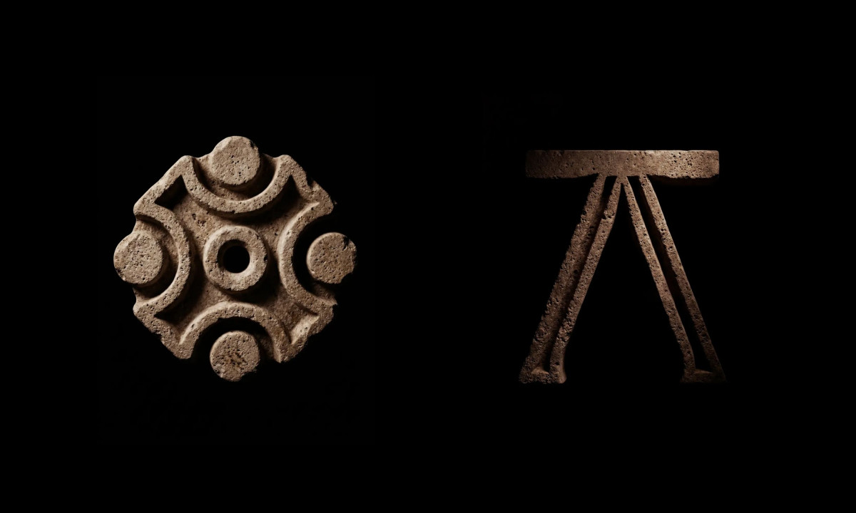 A carved stone circular emblem next to a sharp, triangular letter A