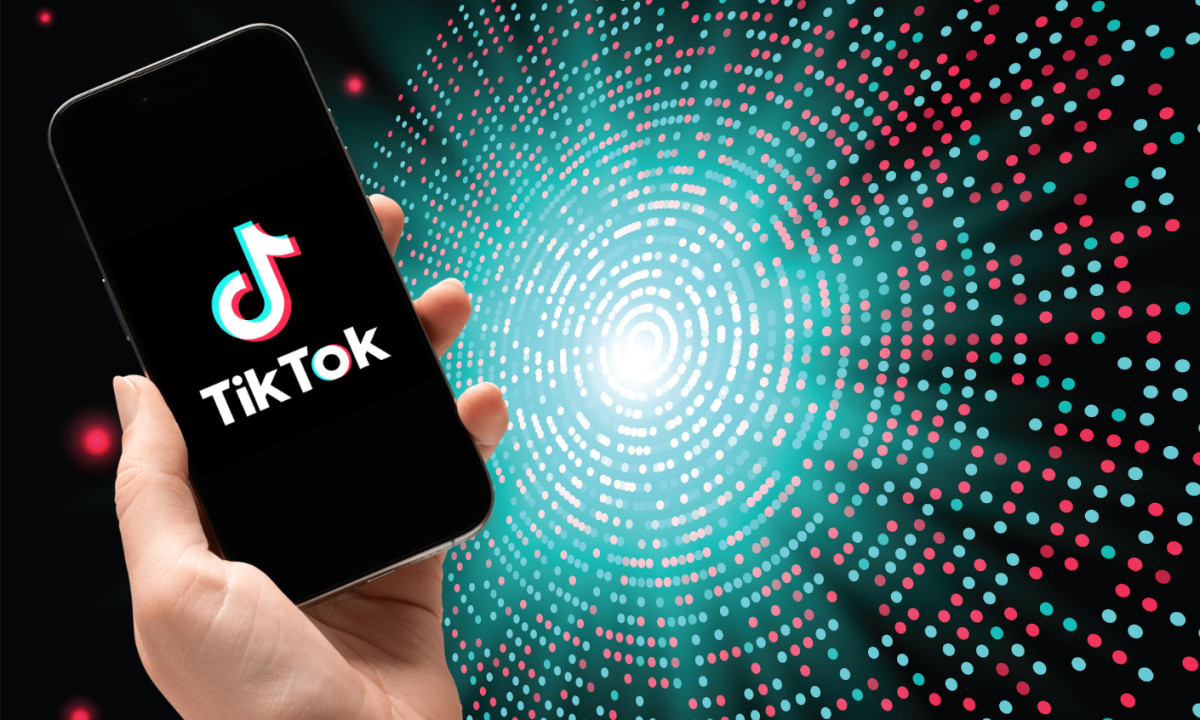 hand holding a mobile phone displaying TikTok logo