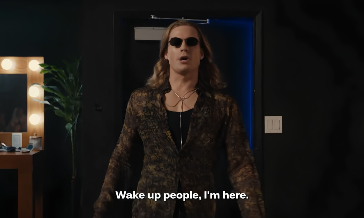 Actor wearing sunglasses walks into a backstage room.