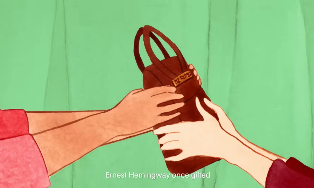 Video frame shows hands exchanging a brown bag.