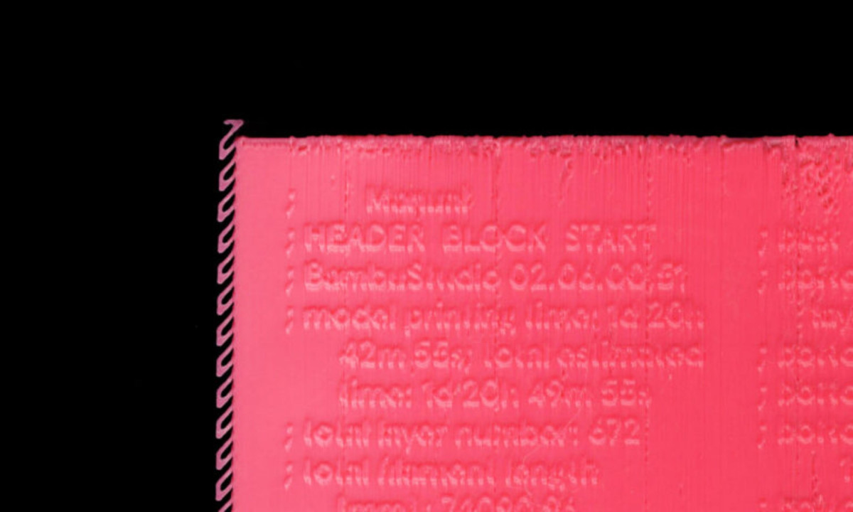 Macro shot features bright pink 3D-printed text.