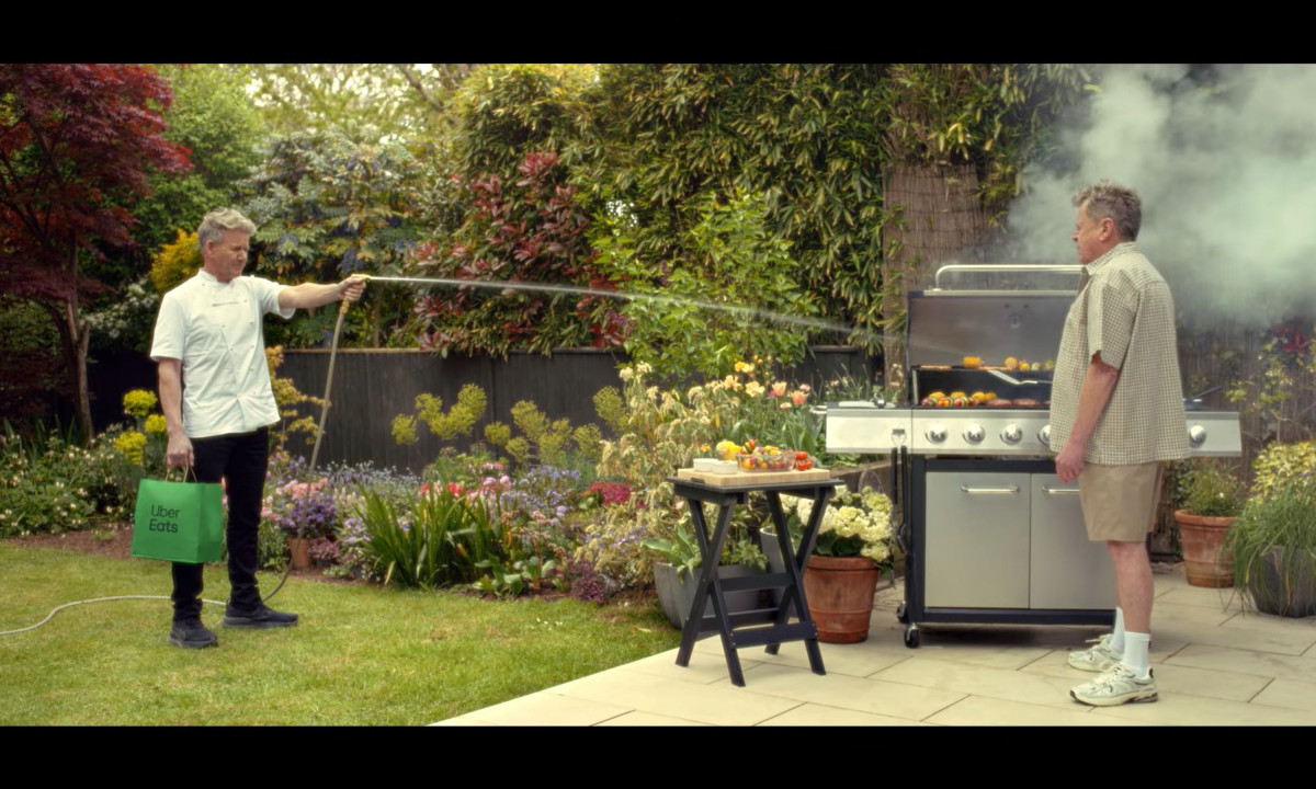 Gordon Ramsay sprays a smoking barbecue with water.