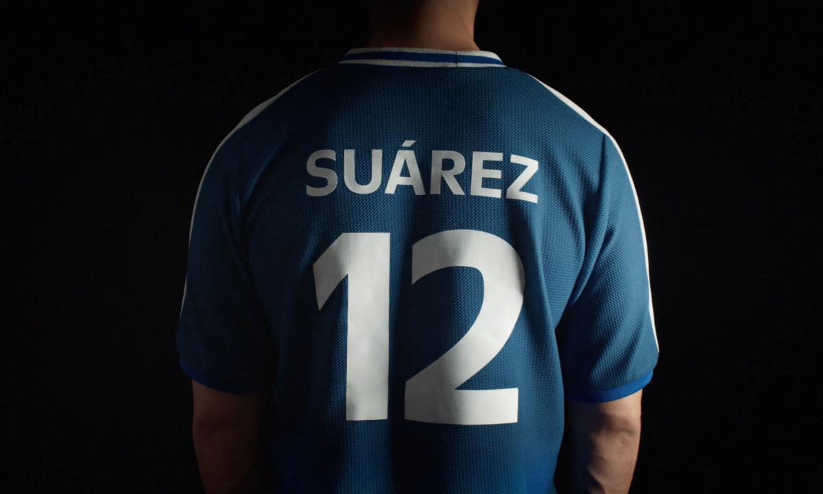 Man models a blue jersey reading Suárez and twelve.