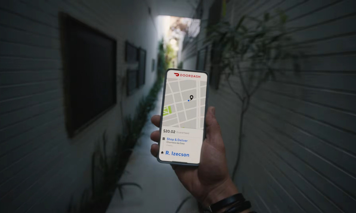 A handheld smartphone displays a delivery route map.