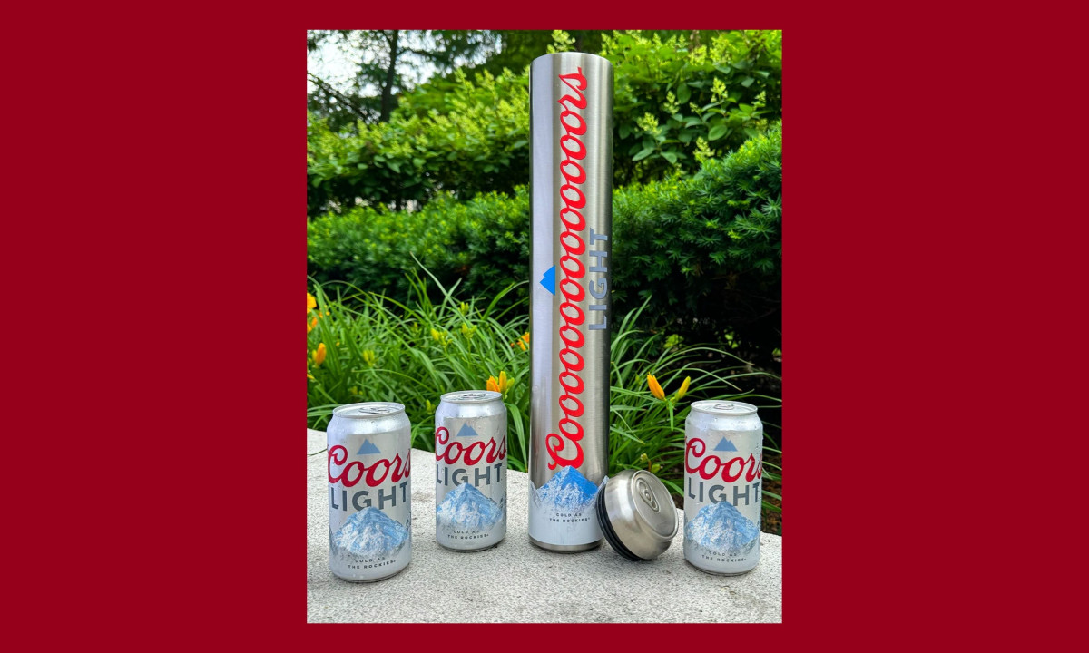 Tall metal canister stands next to three beer cans.