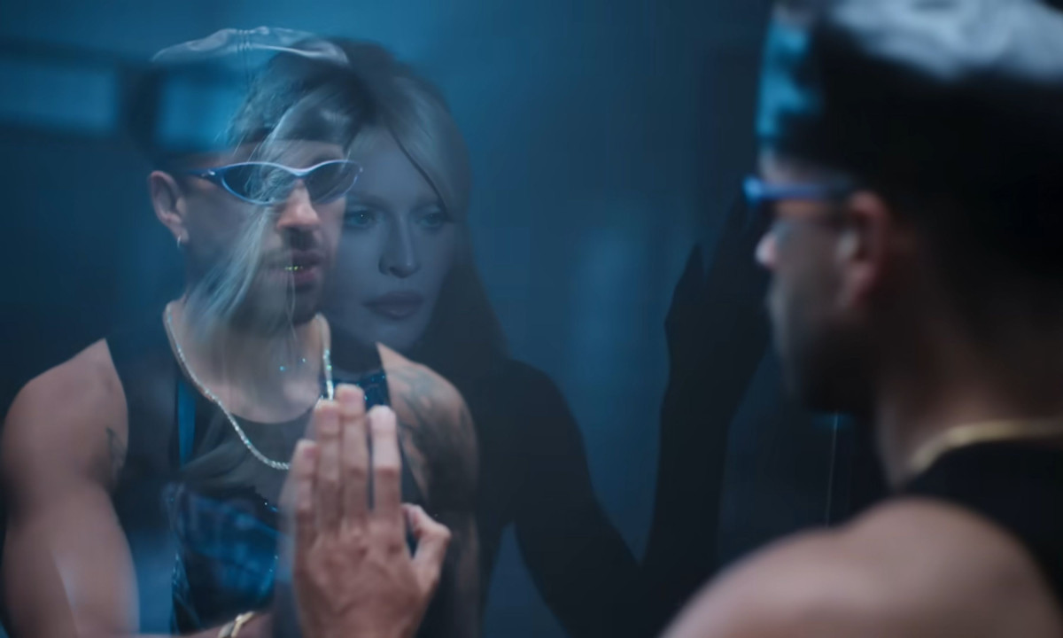 A man's mirror reflection overlaps with Madonna's fading face.