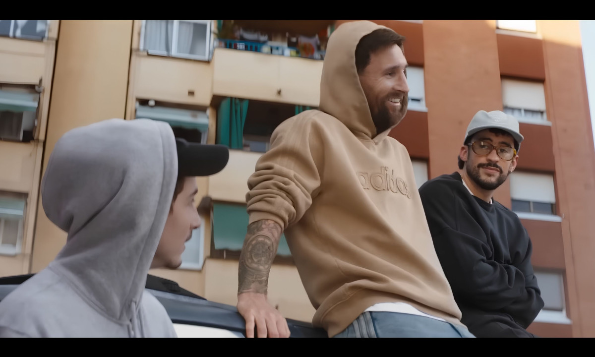 Lionel Messi and Bad Bunny casually lean against a car.