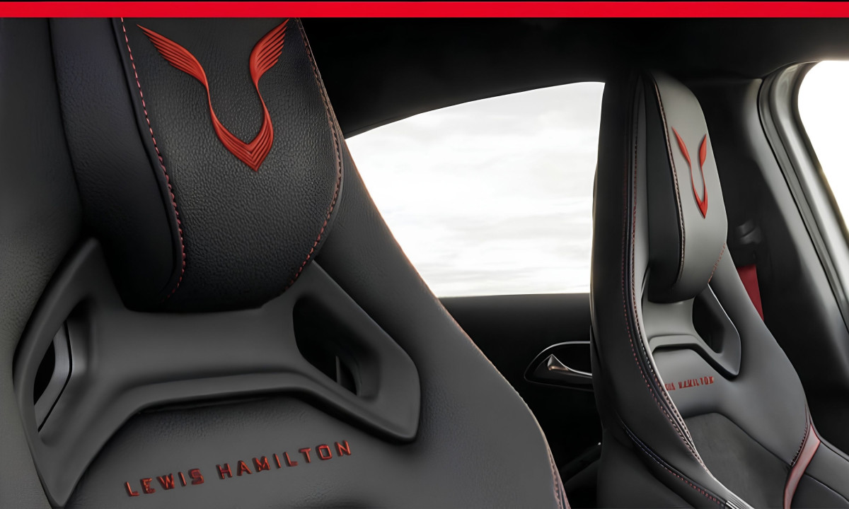 Black leather car seat headrests with red embroidered Lewis Hamilton logo.