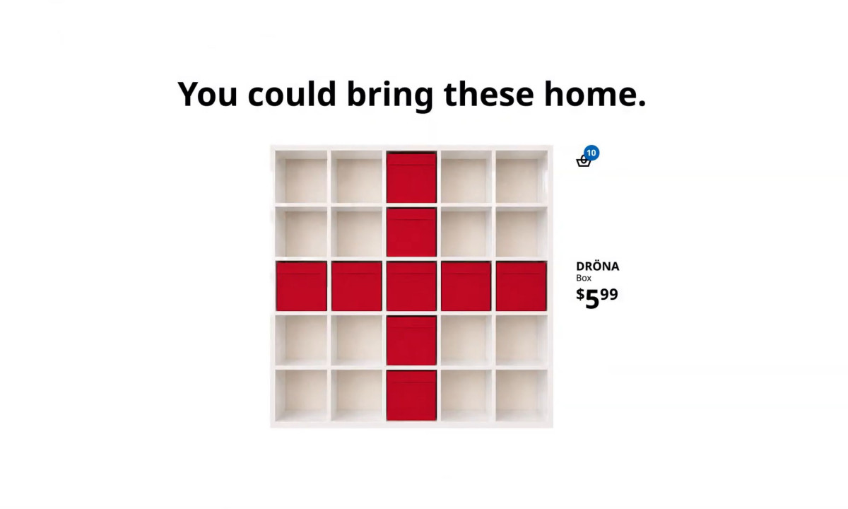 Red DRÖNA storage boxes are arranged in a cross shape inside a white shelving unit next to a price tag.