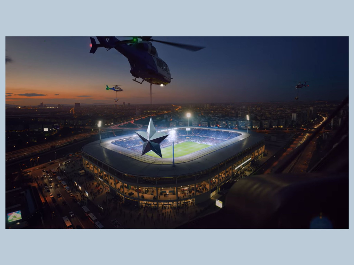Helicopters suspend giant stars over a stadium.