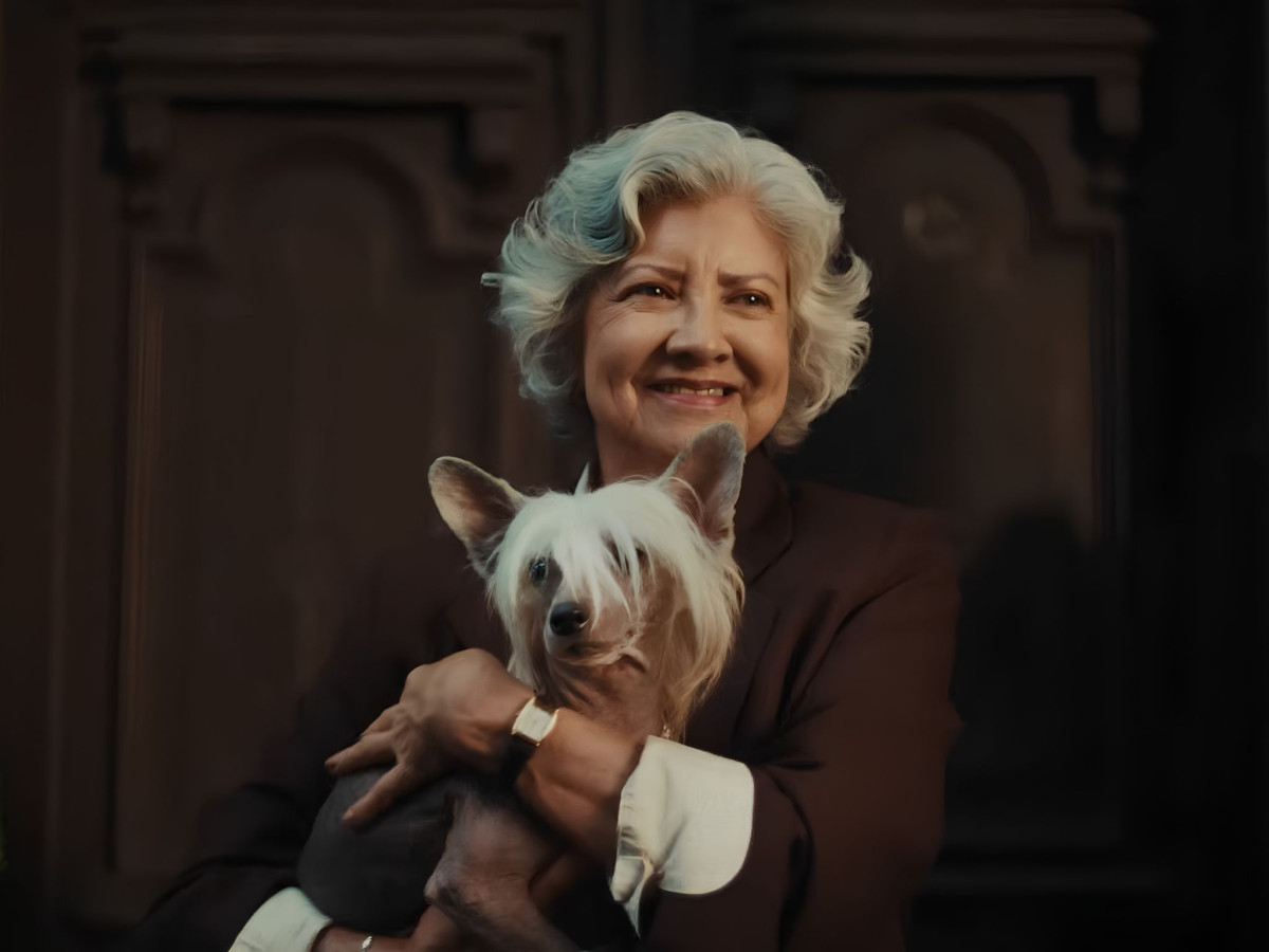 Smiling older woman holding a small dog.