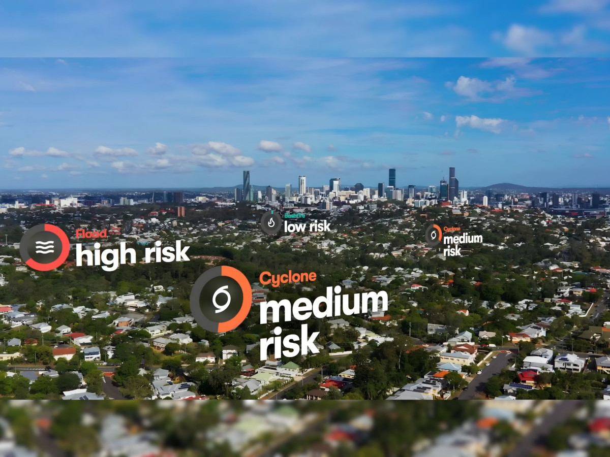 Aerial view of a neighborhood with digital overlays displaying flood, bushfire, and cyclone risk levels.