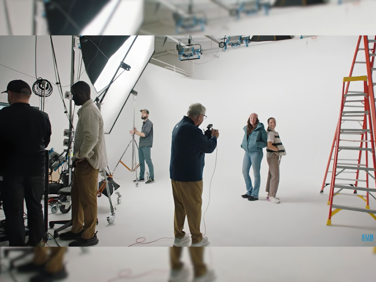 Behind-the-scenes of a studio photo shoot with crew and models.