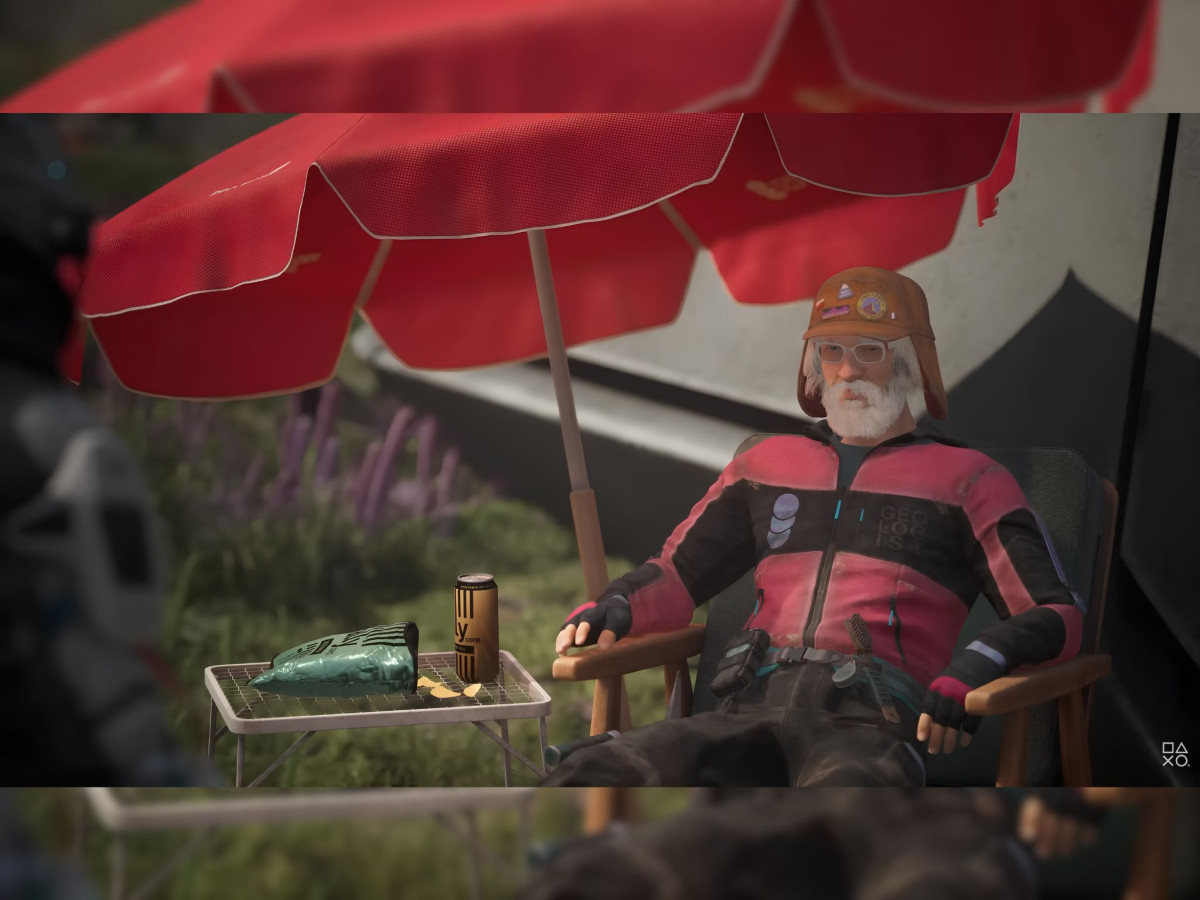 Older man relaxing in a lawn chair under a red umbrella.