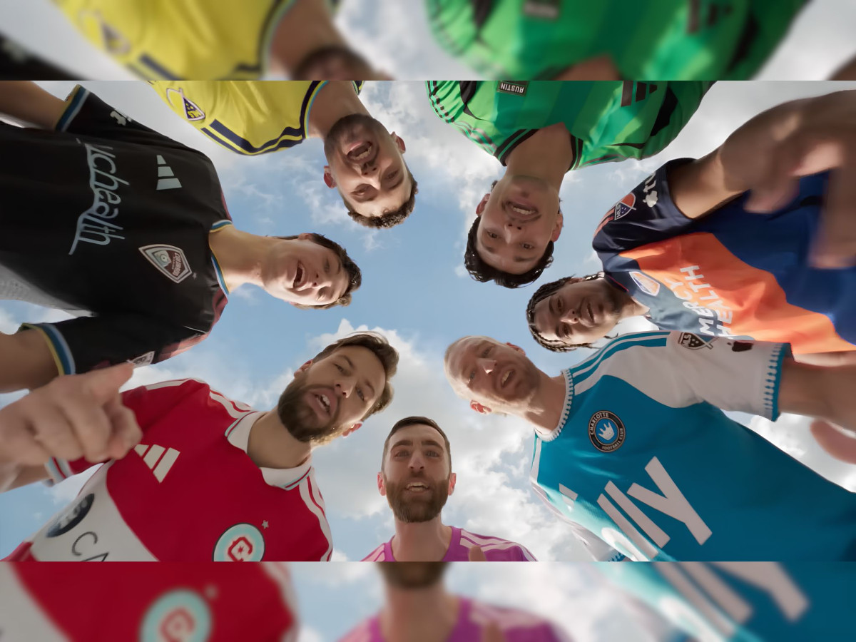 Group of MLS soccer players looking down at camera.