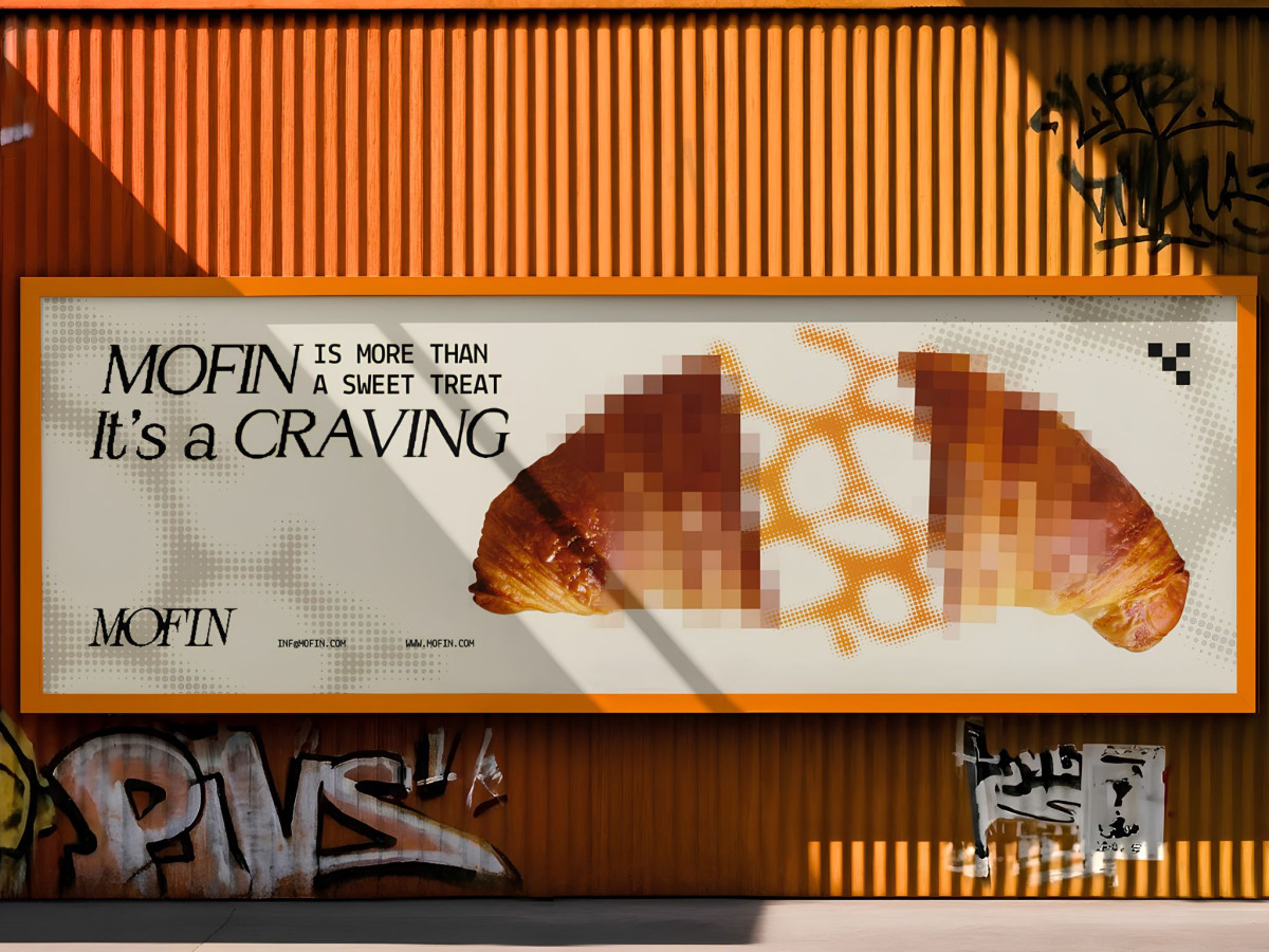MOFIN street billboard featuring a split pixelated croissant on an orange corrugated wall.