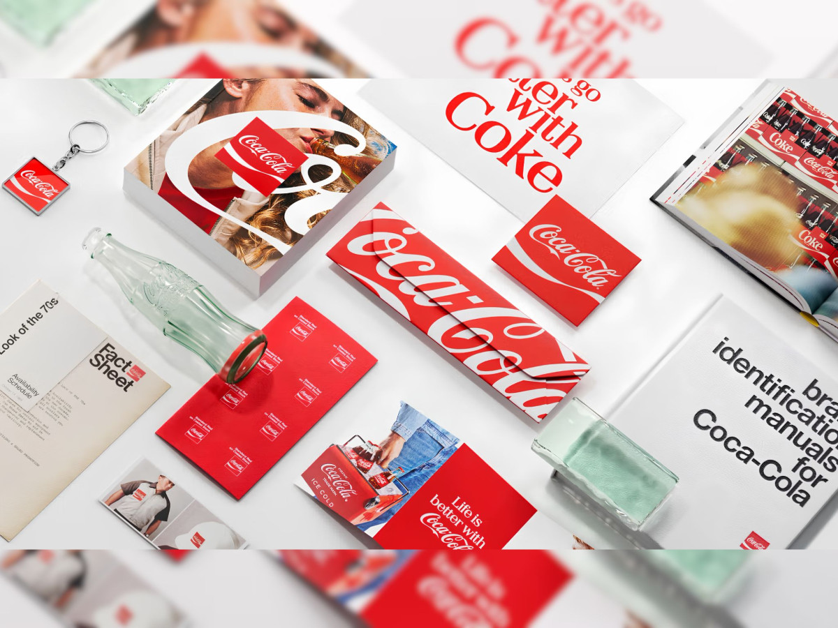 Flat lay of Coca-Cola print materials and brand guidelines.