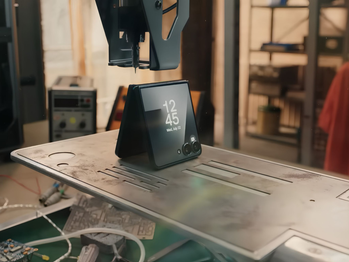 Folded Samsung phone under a robotic fabrication arm.