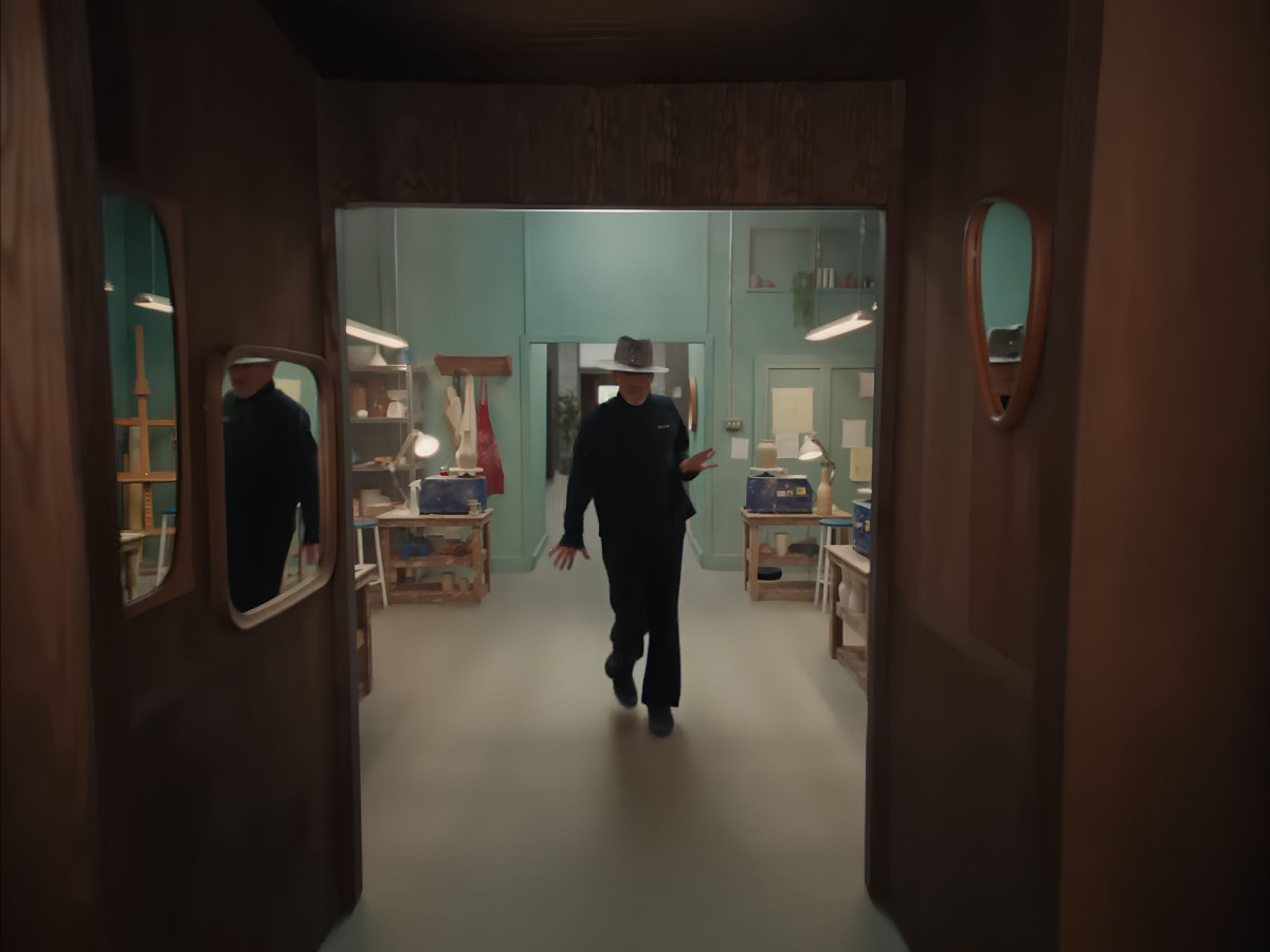 Jay Kay walking in a sliding retro room.