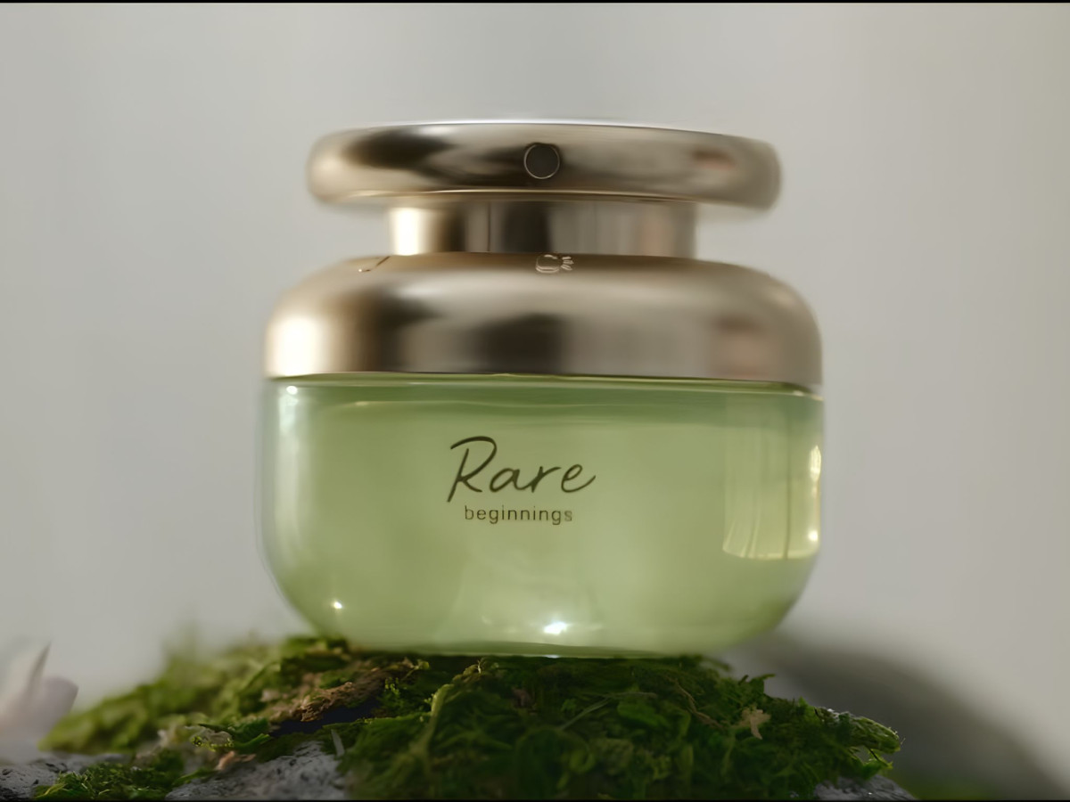 Rare Beginnings green cosmetic jar resting on moss.