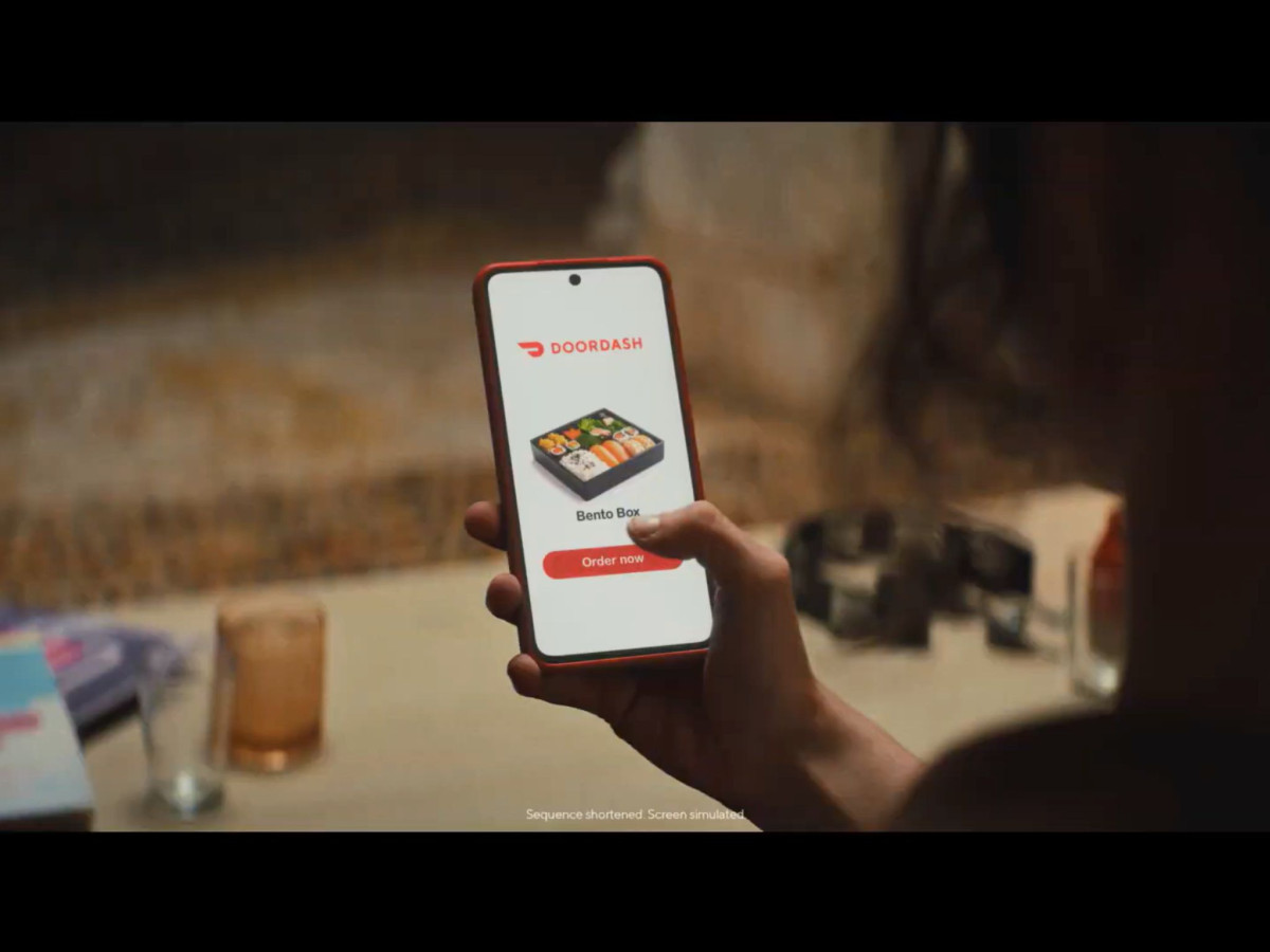 Hand holding a smartphone displaying the DoorDash app.