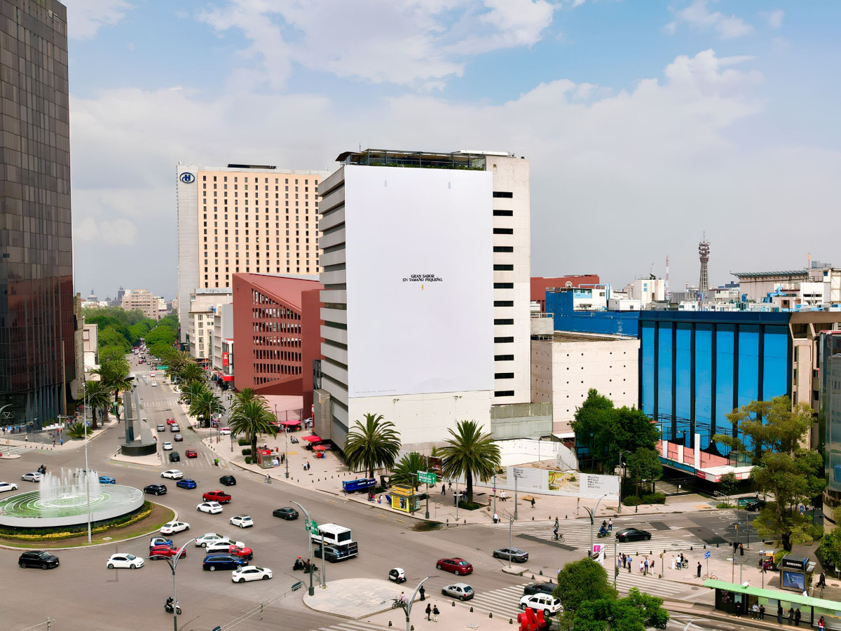 Huge white building billboard with tiny Modelito ad.