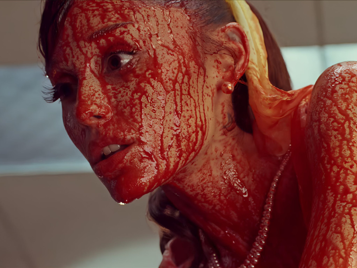 Woman's face and neck completely covered in red liquid.